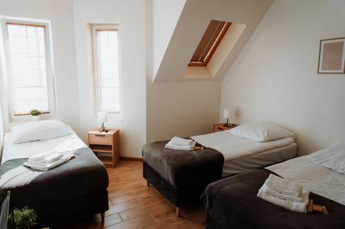 a bedroom with two beds and two windows at Noclegi Przy Stacji in Nowy Dwór Mazowiecki