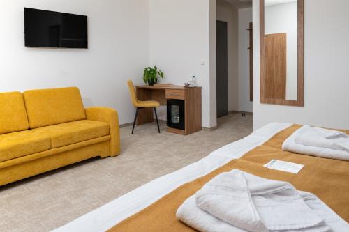a bedroom with a bed and a couch and a desk at Penzion Golf Luby in Luby
