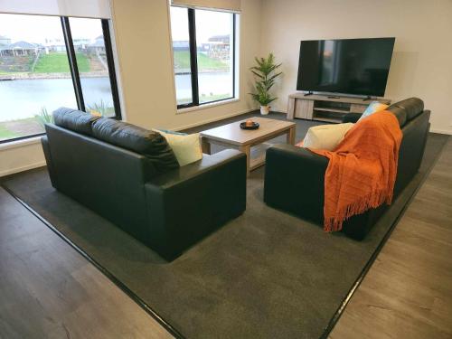 a living room with two couches and a television at RIVER VIEWS in Hindmarsh Island