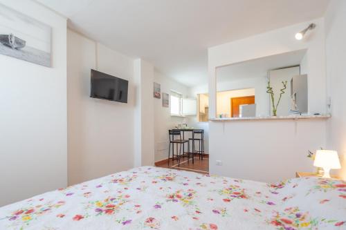 Un dormitorio blanco con una cama y un espejo. en Casa Pizzi - Pescara Centro, en Pescara