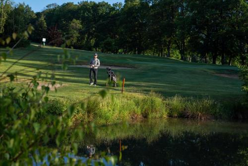 a man and a dog standing next to a pond at Penzion Golf Luby in Luby