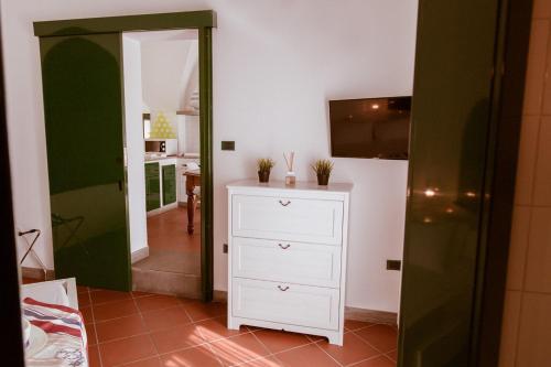 a room with a white dresser and a kitchen at Terrazza Diomede- Manfredi Homes & Villas in Manfredonia