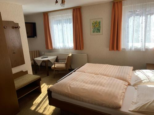 a bedroom with a bed and a table and a chair at Gasthaus Waldhorn in Bad Teinach-Zavelstein