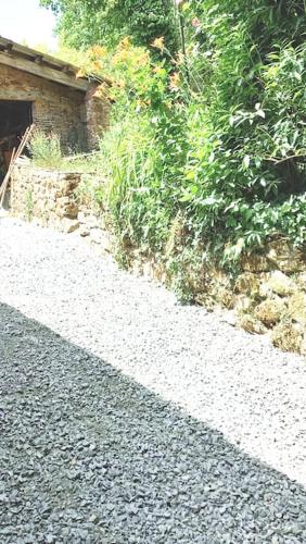 a shadow of a building on a gravel road at Maison au calme avec jardin et parking privé in Rouairoux