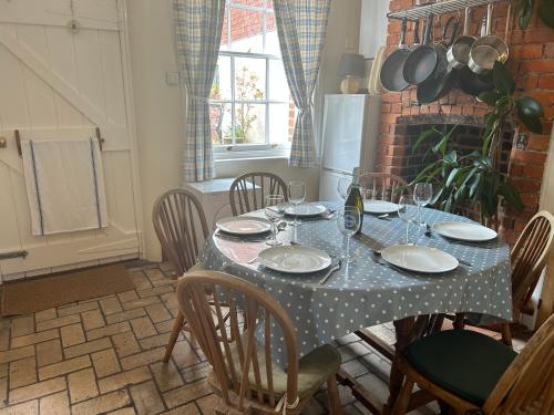 a table with plates and wine glasses on it at Seagulls Cottage in the heart of Exmouth in Exmouth