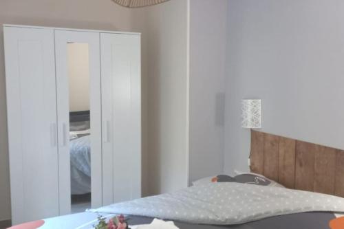 a bedroom with a bed and a mirror at Maison au calme avec jardin et parking privé in Rouairoux