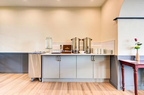 a kitchen with white cabinets and a table at Onich Hotel & Lochside Beach Pods in Onich