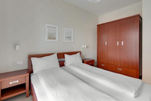 a bedroom with a large bed and a wooden cabinet at GRANO APARTMENTS Gdańsk Old Town SPA & Wellness - GRANO APARTMENTS Gdańsk Residence SPA & Wellness in Gdańsk
