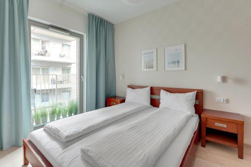 a bedroom with a large bed with a large window at GRANO APARTMENTS Gdańsk Old Town SPA & Wellness - GRANO APARTMENTS Gdańsk Residence SPA & Wellness in Gdańsk