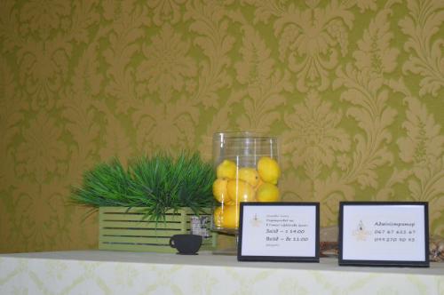 a table with two pictures and a vase of lemons at Дбайлива Ципа in Mizhhirʼʼya