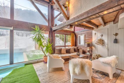 a living room filled with furniture and a large window at Hôtel La Chaumière in Morzine
