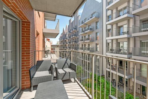 a balcony with chairs and tables on a building at GRANO APARTMENTS Gdańsk Old Town SPA & Wellness - GRANO APARTMENTS Gdańsk Residence SPA & Wellness in Gdańsk