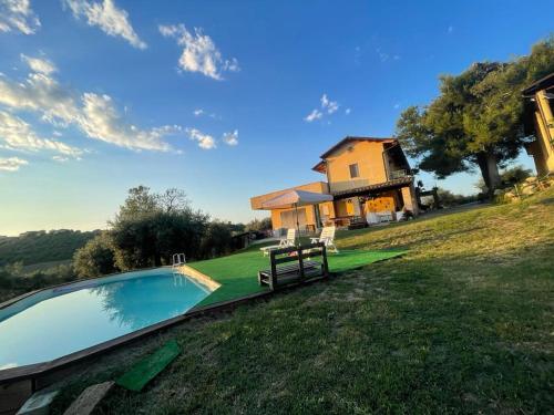 a house with a swimming pool in front of a house at La massaria di Cesare in Pianella