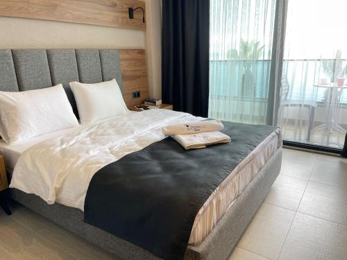 a bedroom with a large bed with two towels on it at Palmon Hotel in Erdek