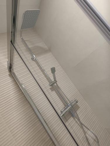 a glass shower door with a chair in a bathroom at Txoko Loft Ribera in Tudela