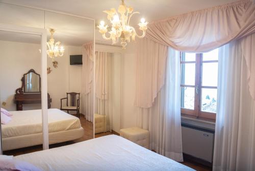 a bedroom with two beds and a mirror and a chandelier at B&B Il Chiostro Assisi in Assisi