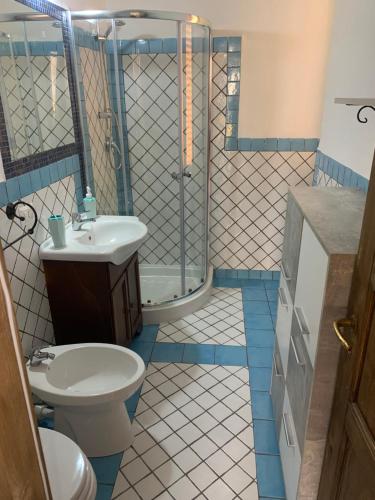 a bathroom with a shower and a toilet and a sink at Casa Balilla 2 in La Maddalena