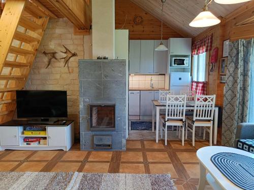 ein Wohnzimmer mit einem Kamin und einem Tisch mit Stühlen in der Unterkunft Poronpolku in Syöte