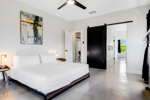 - une chambre avec un lit blanc et un ventilateur de plafond dans l'établissement Outpost Trace, à Lago Vista