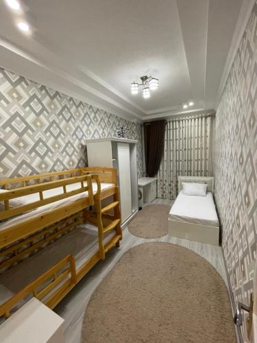 una habitación con dos literas y dos alfombras en Central Apartment, en Samarkand