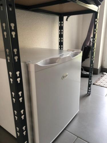 a white cabinet with a sink under a shelf at Le Megève in Sainte-Croix-en-Plaine