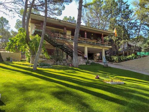 una casa con un gran patio con césped y árboles en Fun Bolarque, en Albalate de Zorita