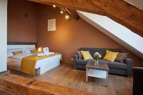 a bedroom with a bed and a couch in a attic at Residence Mariánská in České Budějovice