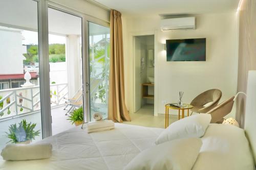 una camera con un grande letto bianco e un balcone di Sirena Suite Deluxe a Peschici