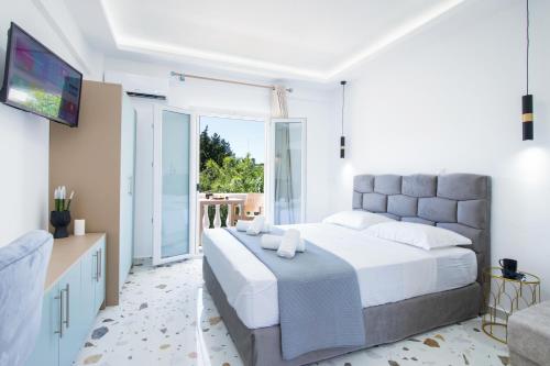 a bedroom with a large bed and a large window at Anais Luxury Living Grey & Pink by CorfuEscapes in Marathias