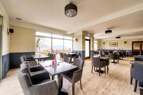 a restaurant with tables and chairs and a large window at Onich Hotel & Lochside Beach Pods in Onich