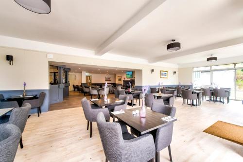 a restaurant with tables and chairs in a room at Onich Hotel & Lochside Beach Pods in Onich