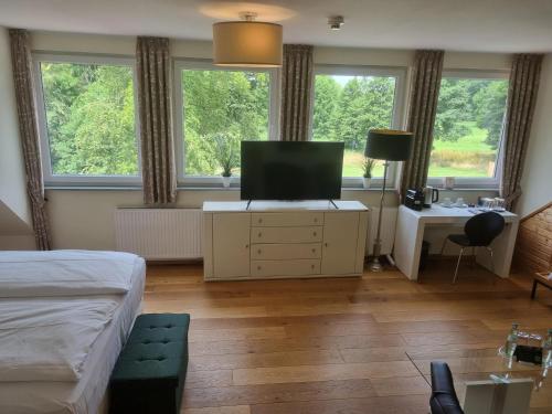 a bedroom with a bed and a television on a dresser at Die LÜ - Lüttelforster Mühle in Schwalmtal