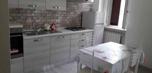 una cucina con frigorifero bianco e tavolo di Casetta Monterano a Canale Monterano