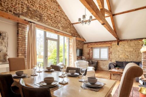 a dining room with a wooden table and chairs at The Cart Lodge - relaxing rural spa break in Pentney