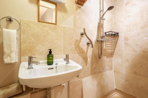 a bathroom with a sink and a shower at The Cart Lodge - relaxing rural spa break in Pentney