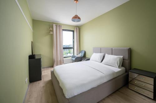 華沙的住宿－Mokotów Colourful Apartment，卧室设有一张白色大床和一扇窗户。