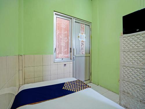 a small room with a bed and a window at OYO Life 92653 Homestay Griya Nautika Syariah in Surabaya