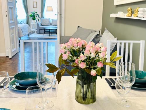 a vase filled with pink flowers sitting on a table at The Spot with Green Chair - cozy space near Danube in Budapest