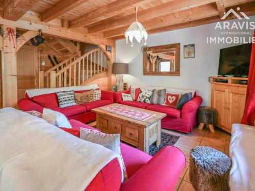 a living room with red couches and a tv at Chalet Le Grand-Bornand, 8 pièces, 16 personnes - FR-1-391-33 in Le Grand-Bornand
