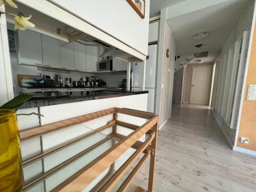 a kitchen with white cabinets and a wooden floor at Raita Villa in Savonlinna
