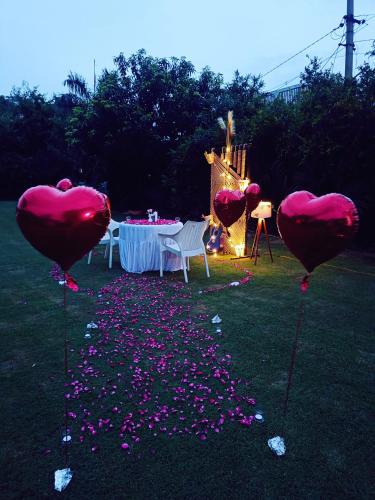 a table with heart balloons in the grass with confetti at Green Club Farm in Ajmer
