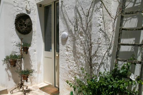 a white building with a door and a window at B&B Pulia Dimore Salentine Leuca in Alessano