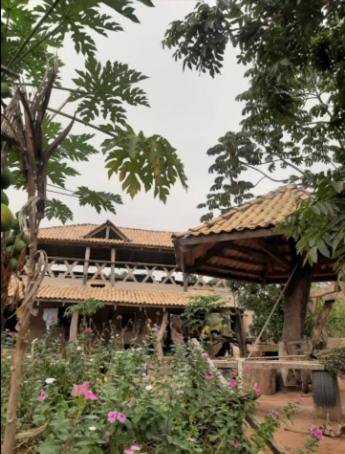 uma casa com um pavilhão num jardim com flores em Pousada Peraputanga em Estivado