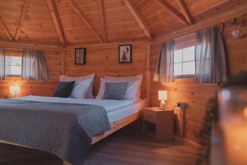 a bedroom with a bed in a wooden cabin at GLAMPING IZLETIŠTE BANOVAC in Gornje Komarevo