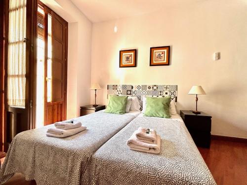 um quarto com uma cama grande e toalhas em Hispalis San Julian em Sevilha