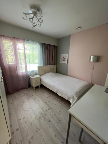 a small bedroom with a bed and a window at Raita Villa in Savonlinna