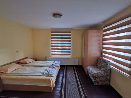 ein Schlafzimmer mit einem Bett, einem Stuhl und einem Fenster in der Unterkunft Комплекс Петлето in Smoljan