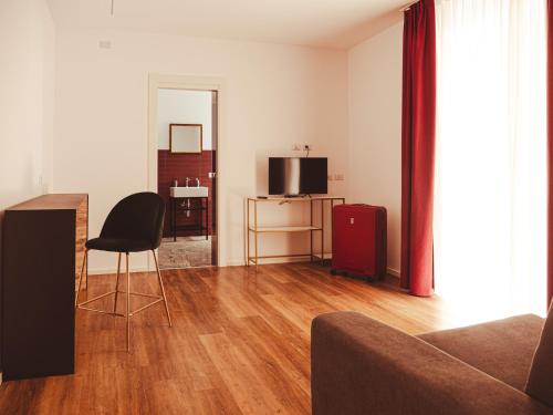 ein Wohnzimmer mit einem Sofa, einem Stuhl und einem TV in der Unterkunft U Zuccareddu in Alcamo