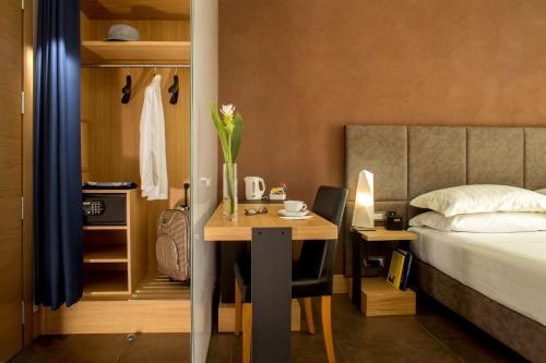 ローマにあるベスト ウエスタン プラス スプリング ハウスのデスクとベッド付きの客室と、ベッド付きの客室を提供しています。