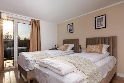 two beds in a bedroom with a balcony at Syrenka in Solec-Zdrój